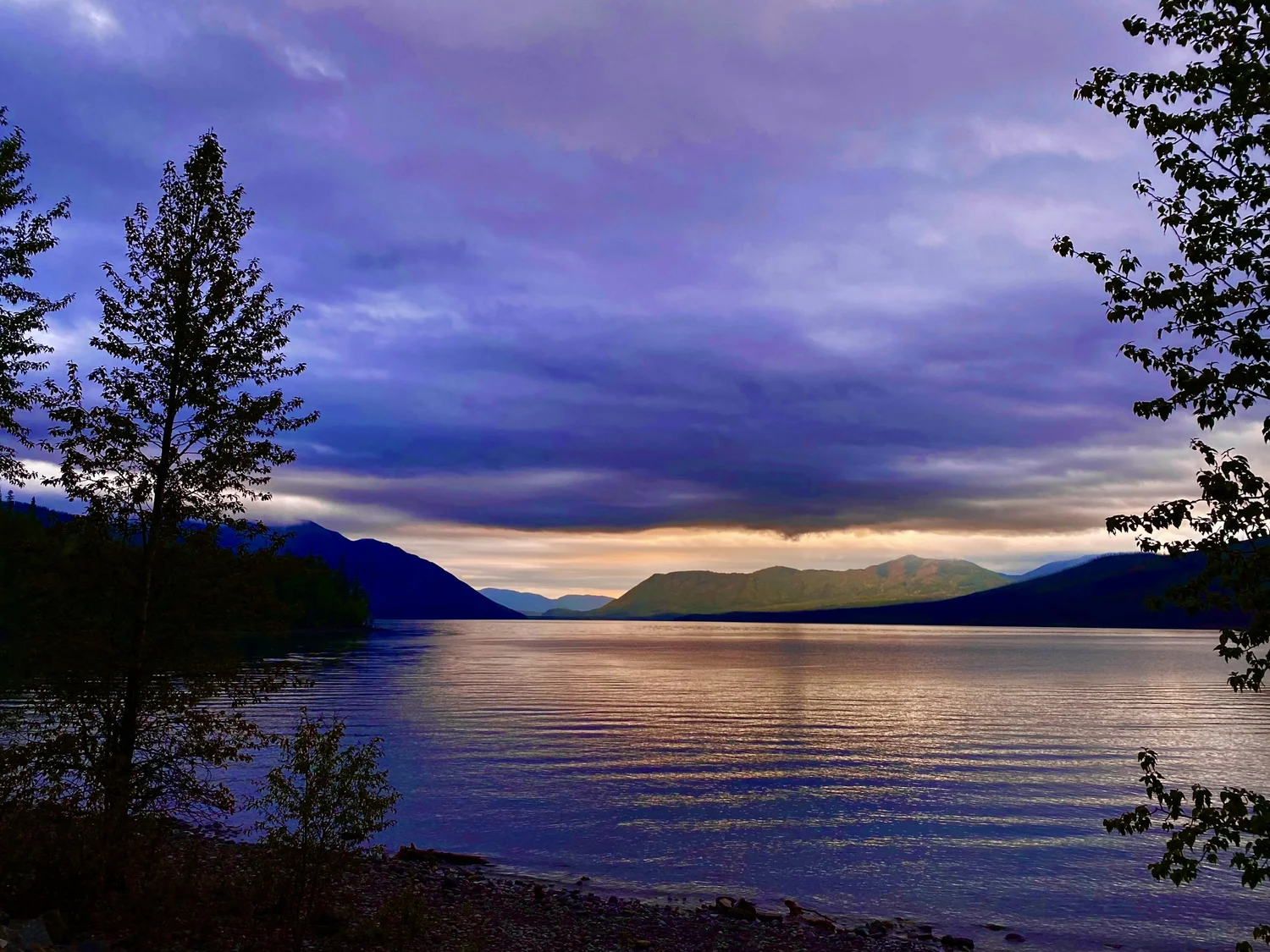 Scenic view of a lake at sunset with mountains in the background